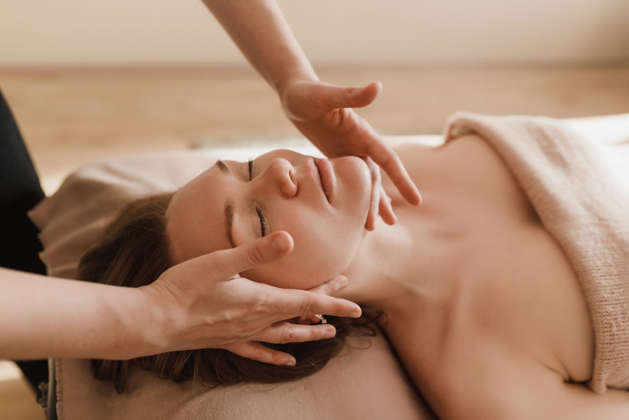 Home Woman receiving a soothing facial massage, promoting relaxation and wellness.